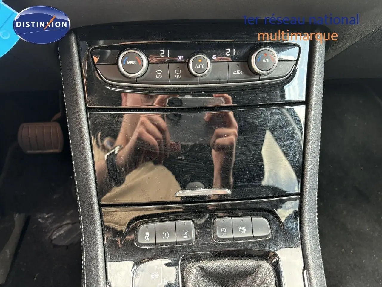 Vue rapprochée du tableau de bord noir brillant de l’Opel Grandland X 2019 avec commandes de climatisation et boutons fonctionnels.