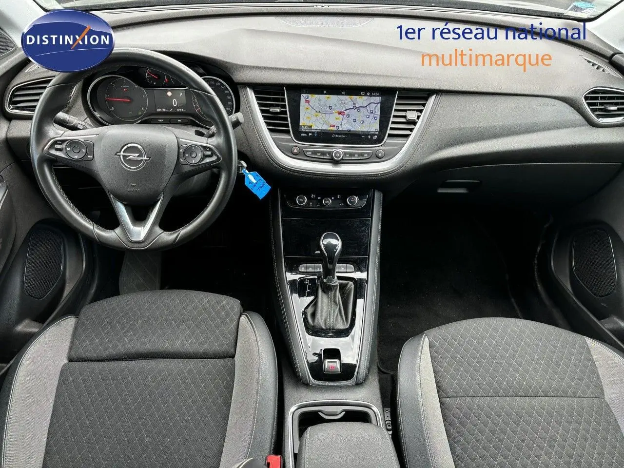 Vue intérieure avant de l’Opel Grandland X noir, montrant le tableau de bord, volant multifonction et console centrale avec boîte automatique.