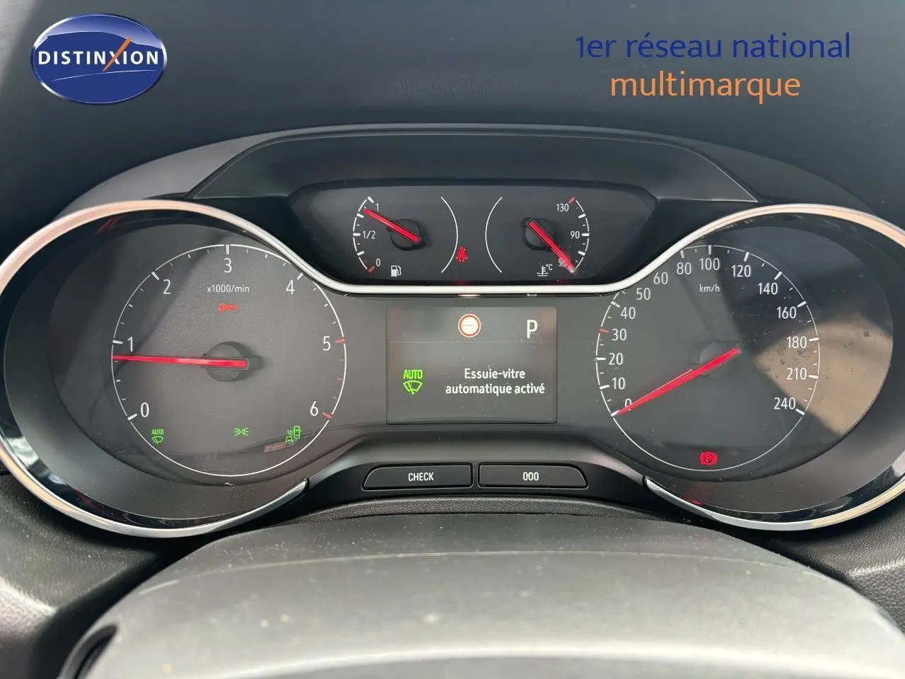 Tableau de bord de l'Opel Grandland X noir, affichant compte-tours, vitesse et écran central avec essuie-vitre automatique activé.