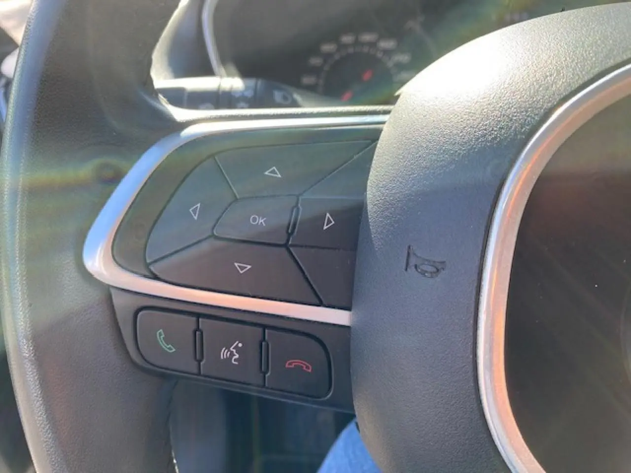 Gros plan sur les commandes au volant côté gauche du Fiat Tipo 2018, avec boutons de navigation et téléphone.