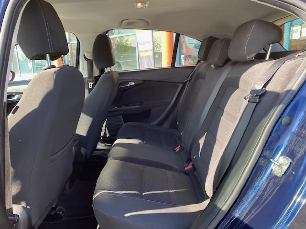 Vue intérieure côté droit des sièges arrière noirs d'une FIAT TIPO bleu métallisé 2018 avec porte ouverte.