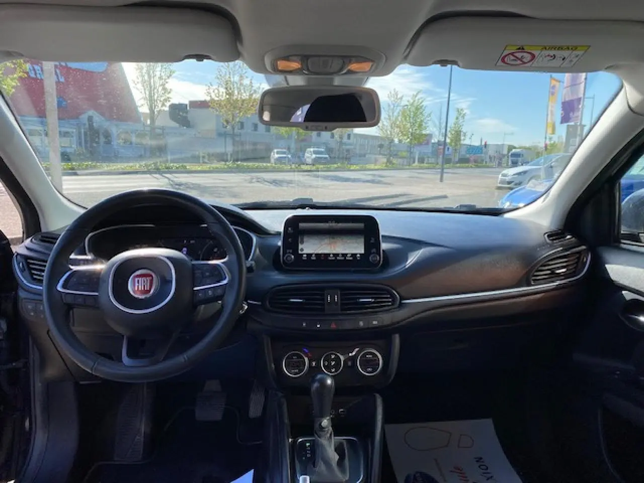 Vue intérieure avant du Fiat Tipo 2018 bleu, montrant le volant, l’écran tactile central et la console avec boîte automatique.