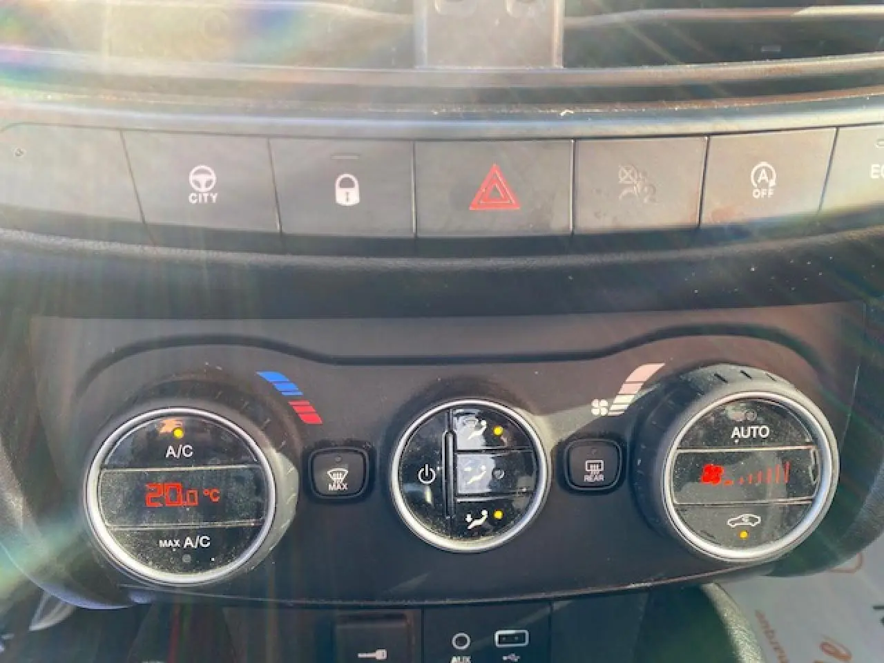 Gros plan sur les commandes de climatisation du tableau de bord d'une Fiat Tipo 2018, éclairage naturel.