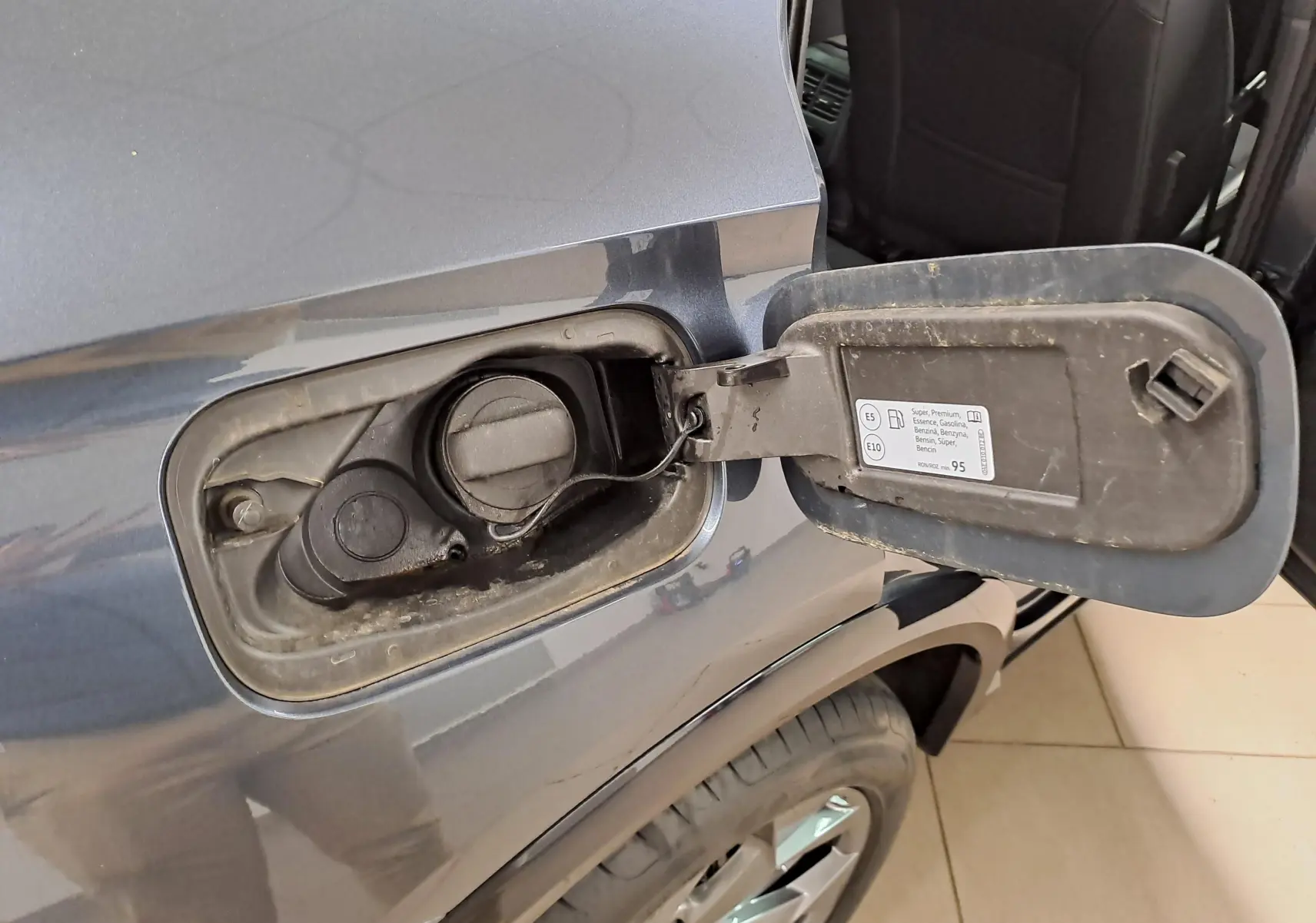 Détail de la trappe à carburant côté gauche d’un CUPRA Formentor gris magnétique avec bouchon essence ouvert.