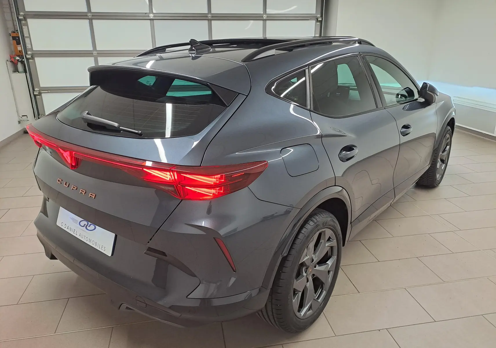 Vue 3/4 arrière droite du CUPRA Formentor gris magnétique avec feux arrière Tri-LED et jantes alliage 18 pouces.