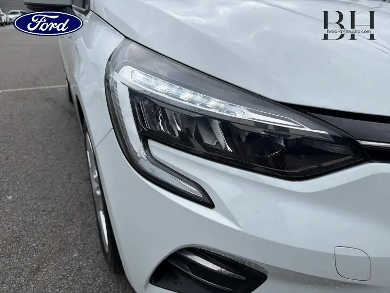 Gros plan sur le phare avant droit blanc glacier de la Renault Clio 1.6 E-Tech hybride 2021 avec feux LED distinctifs.