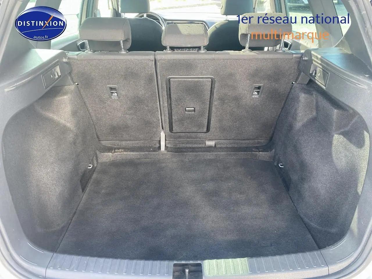 Coffre ouvert vu de l'arrière d'un SEAT Ateca gris 2020, montrant la banquette arrière et l'espace de chargement vide.