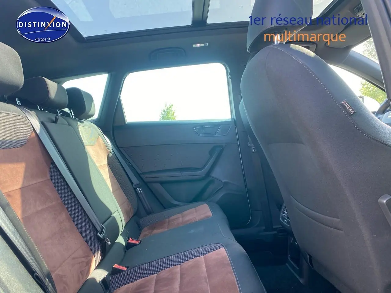 Vue intérieure arrière côté droit du SEAT Ateca gris 2020, montrant les sièges en alcantara brun et toit panoramique.