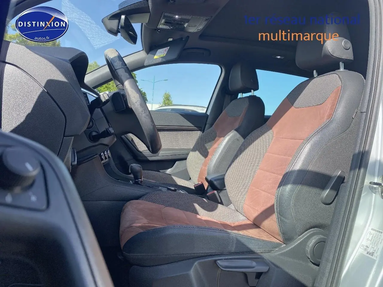 Vue intérieure côté gauche du SEAT Ateca 2020, sièges sport en alcantara brun et tissu gris, volant cuir multifonction.
