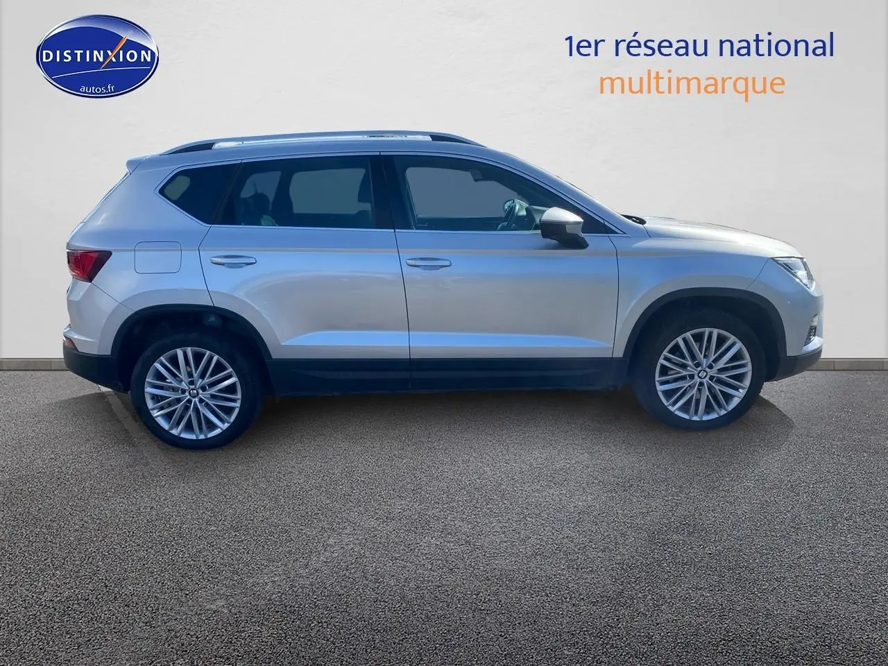 Vue latérale droite d'un SEAT Ateca gris 2020 avec jantes alliage et rétroviseurs argentés sur fond neutre.