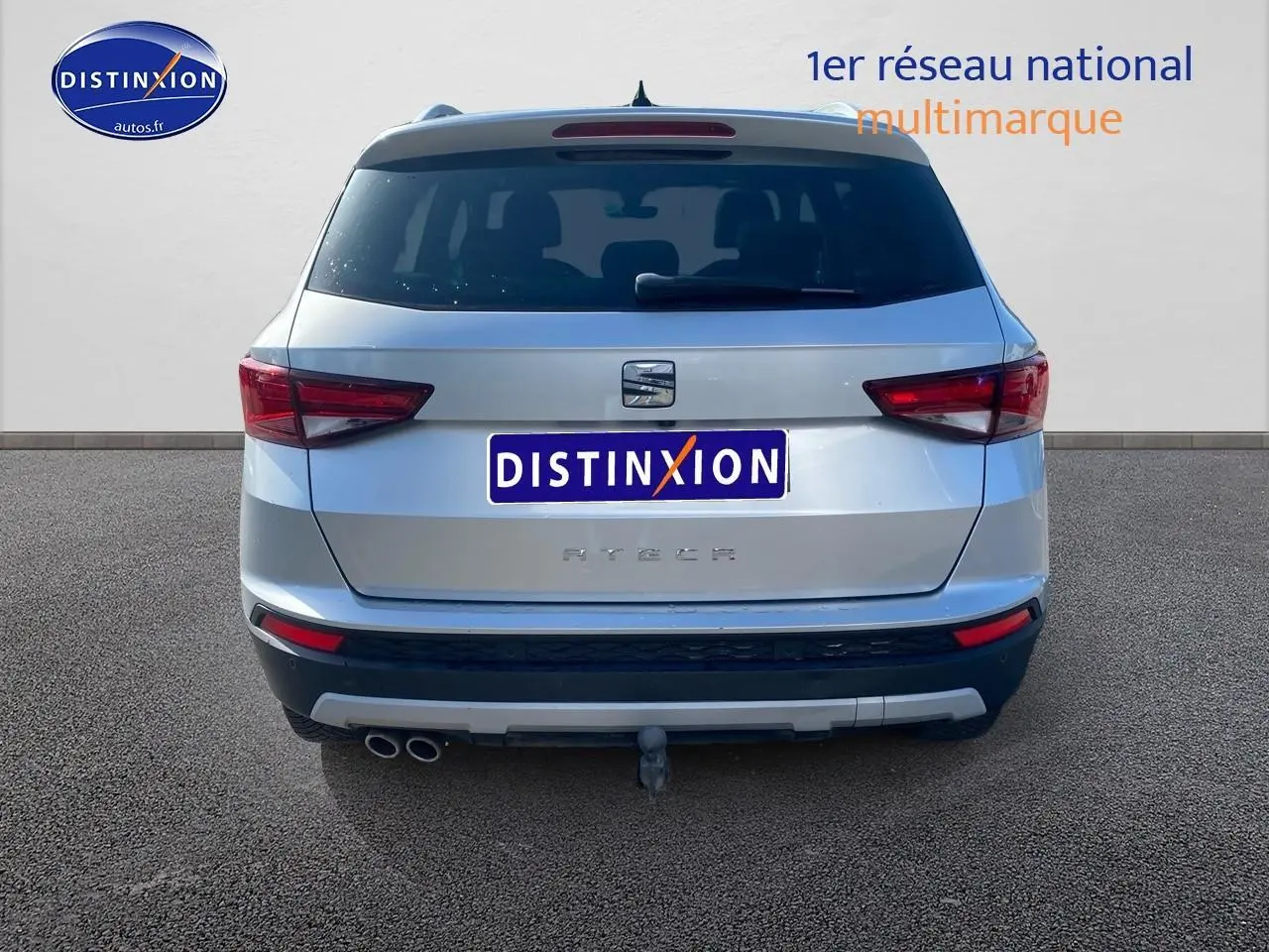 Vue arrière d'un SEAT Ateca gris 2020 avec double sortie d'échappement et attelage visible.