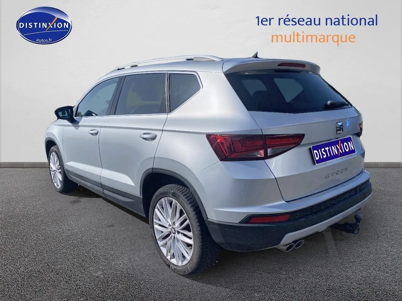 Vue 3/4 arrière droite d'un SEAT Ateca gris 2020 avec jantes alu et double sortie d'échappement chromée.