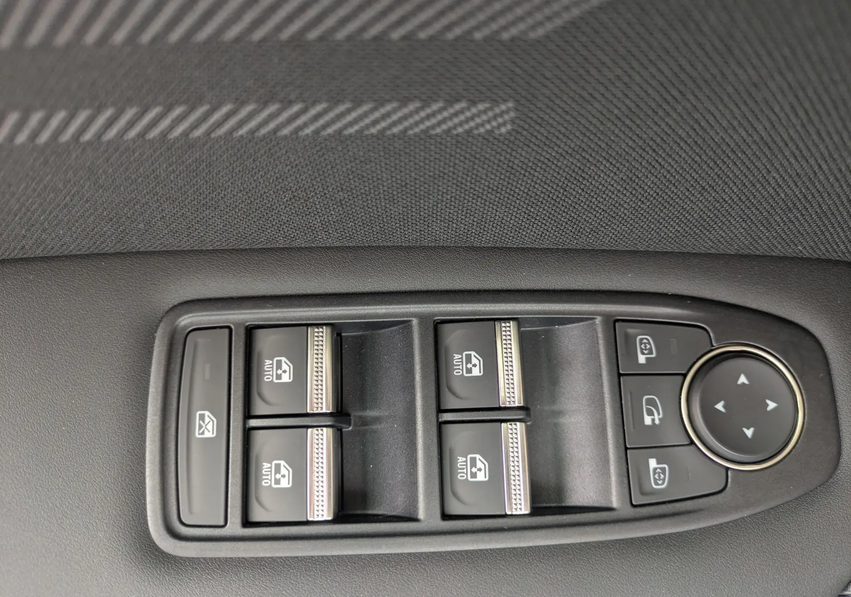 Panneau de commandes des vitres électriques et rétroviseurs sur porte avant gauche d’une Renault Symbioz gris Rafale métal.