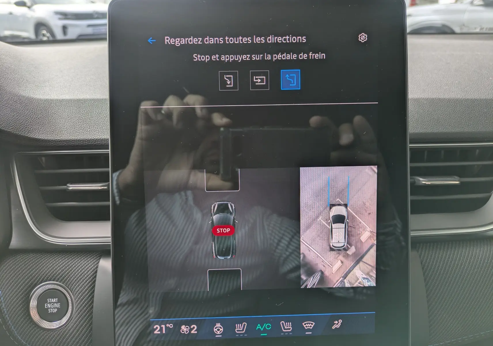 Écran tactile central du Renault Symbioz 2026 affichant l'aide au stationnement avec vue aérienne et instructions de freinage.