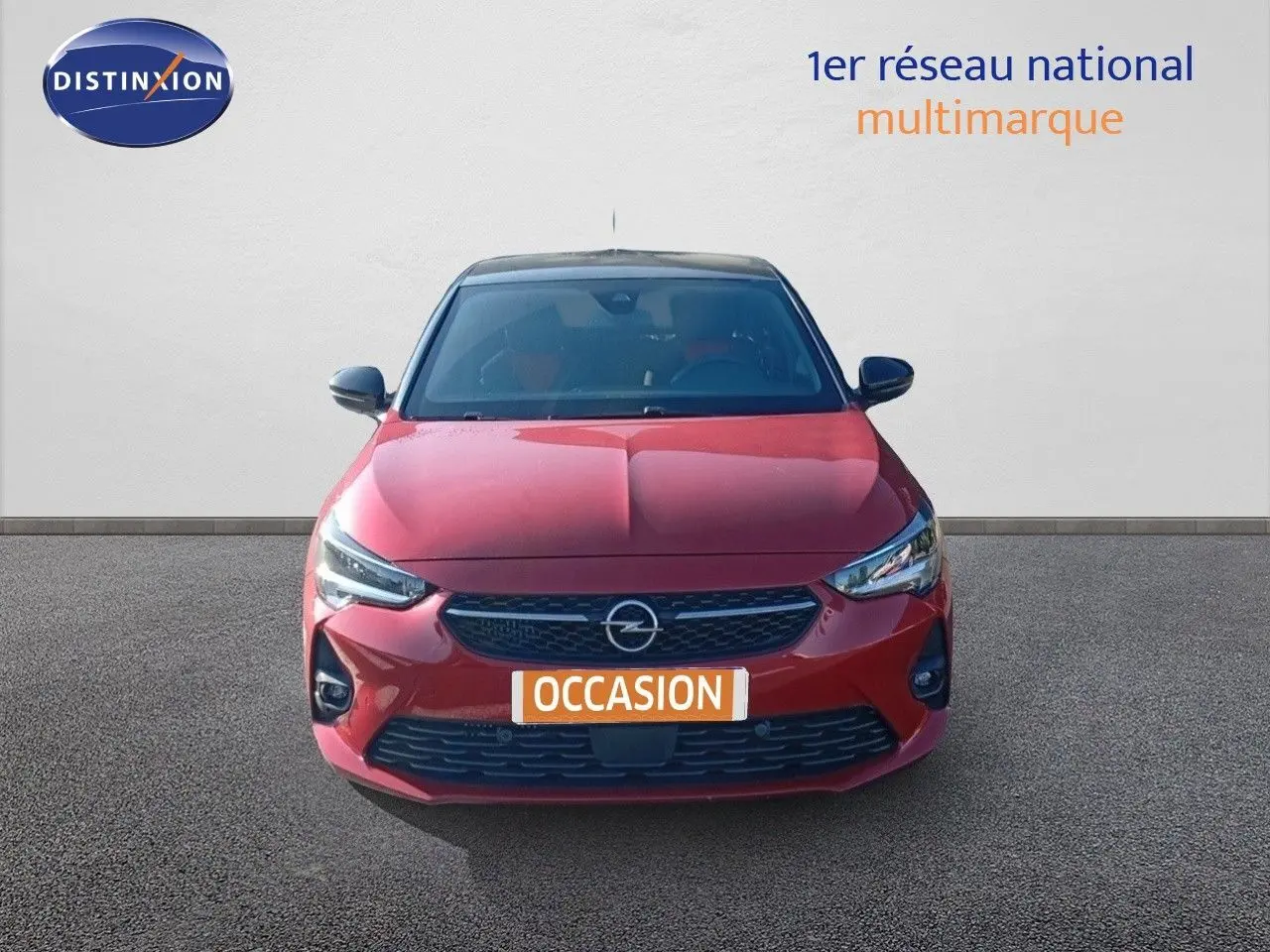 Vue de face d'une Opel Corsa 1.2 Turbo rouge métal avec toit noir, calandre et phares LED distinctifs.
