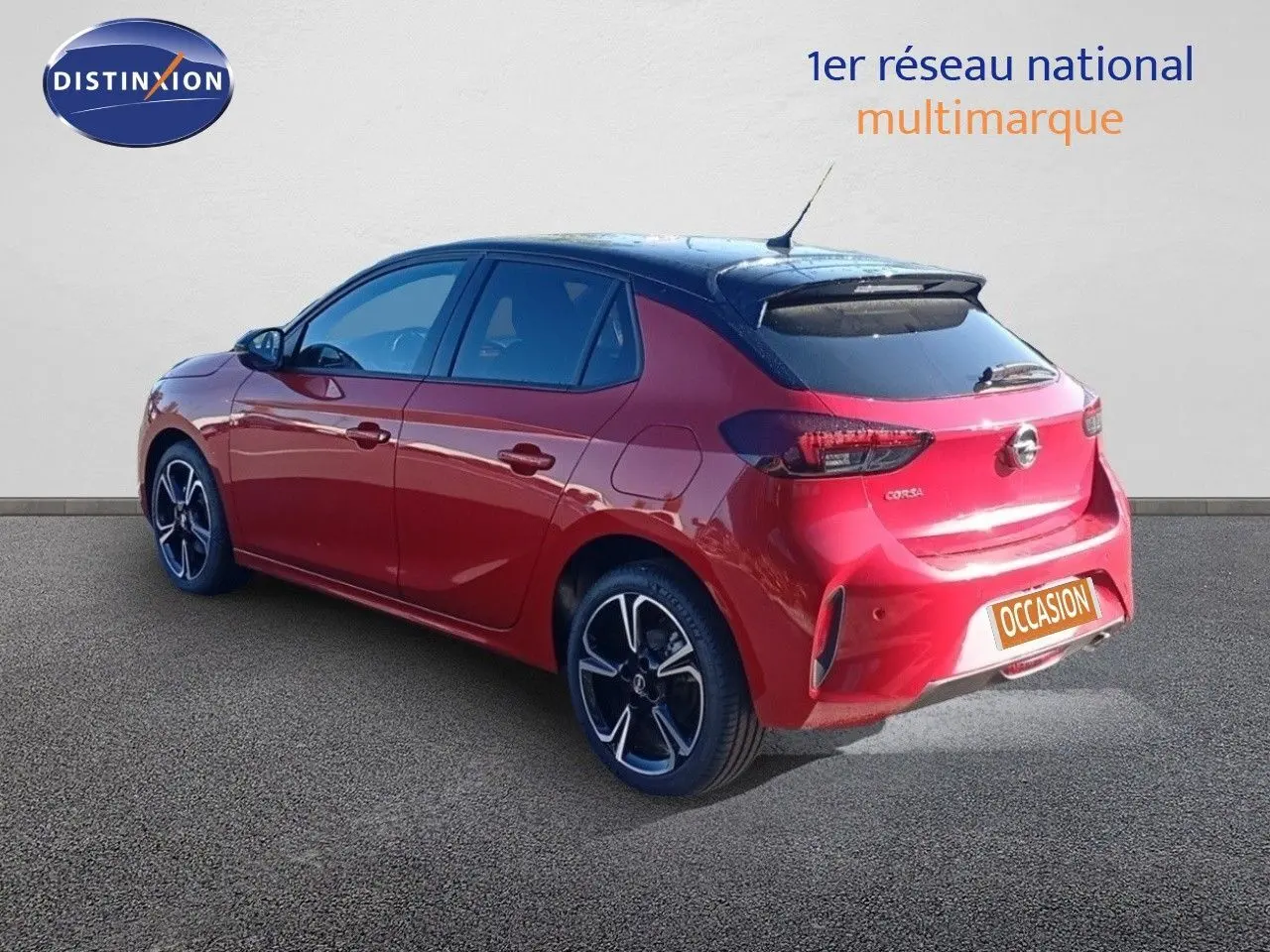 Opel Corsa rouge métal avec toit noir en 3/4 arrière droit, jantes alliage et feux arrière LED visibles.