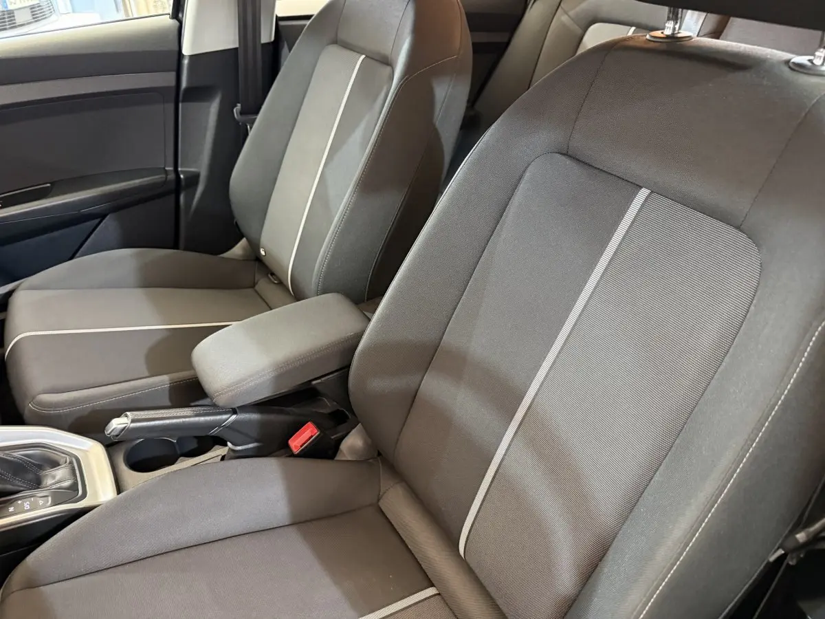 Vue rapprochée des sièges avant gris foncé avec bande claire centrale dans l’Audi A1 2021, côté conducteur.