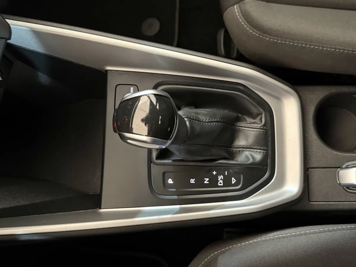 Le levier de vitesses automatique noir de l'Audi A1 2021 vu de dessus, entouré de garniture argentée.