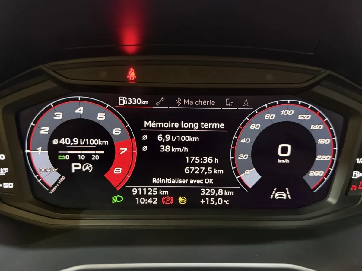 Tableau de bord numérique de l'Audi A1 noir, affichant la consommation, vitesse et informations de conduite.