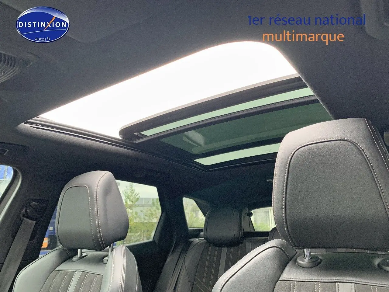 Intérieur du Peugeot 3008 gris platinium, vue sur les sièges avant en cuir noir et toit ouvrant panoramique.