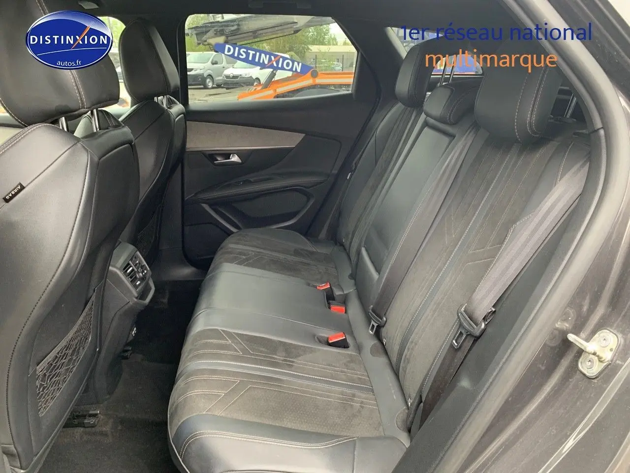 Vue intérieure côté droit montrant la banquette arrière en cuir noir avec surpiqûres du Peugeot 3008 gris platinium.