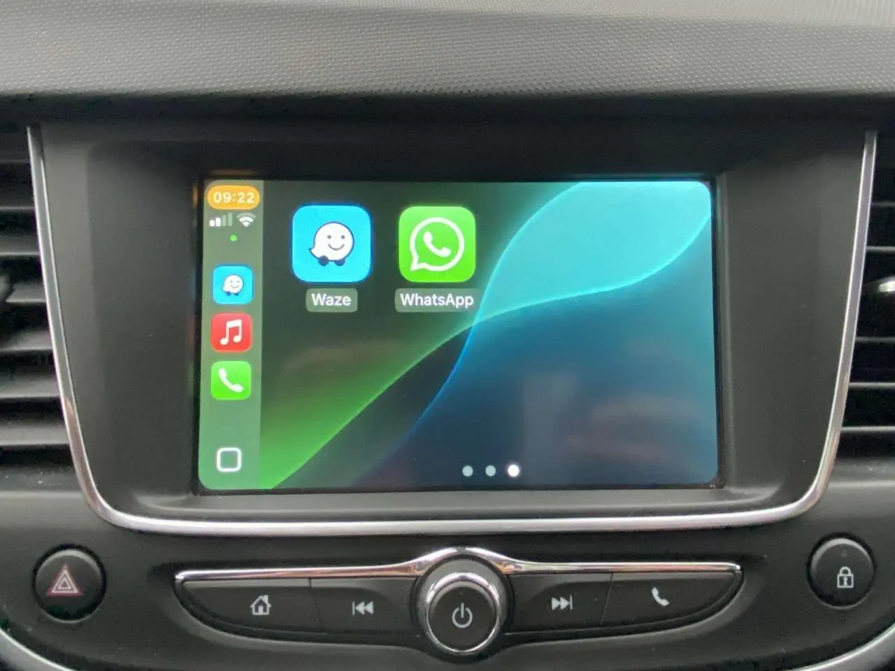 Écran tactile central de l’Opel Crossland X 2020 affichant les applications Waze et WhatsApp, entouré de commandes noires.