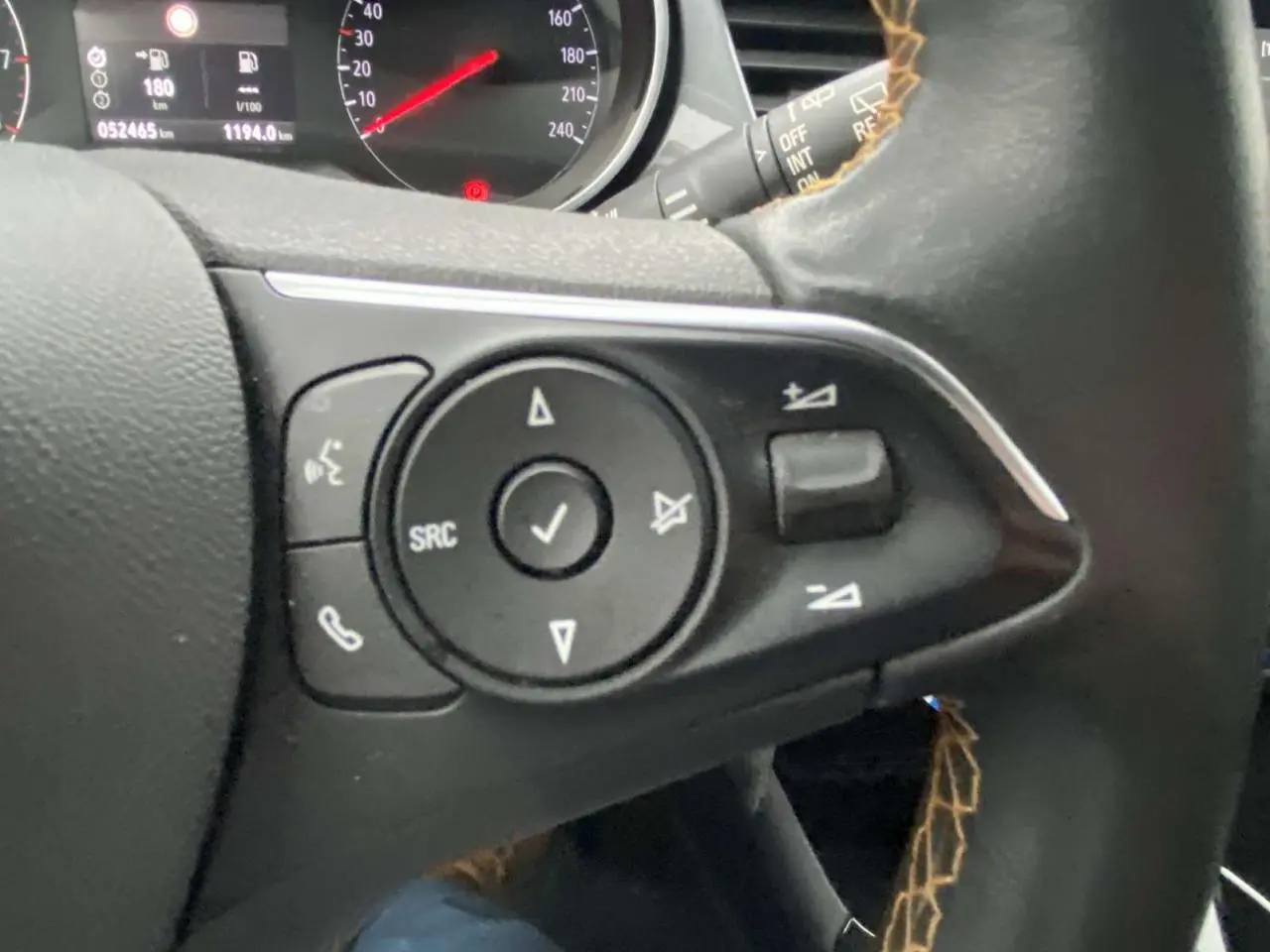 Gros plan sur les commandes au volant à gauche de l'Opel Crossland X 2020, tableau de bord partiellement visible.