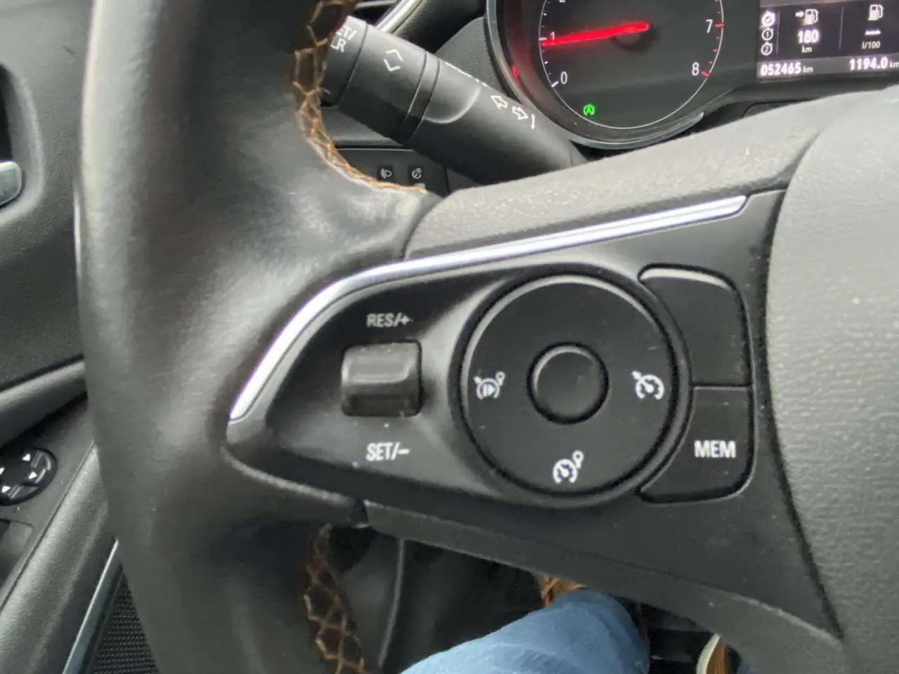 Gros plan sur le volant noir de l'Opel Crossland X 2020, montrant les commandes de régulateur de vitesse et le tableau de bord partiel.