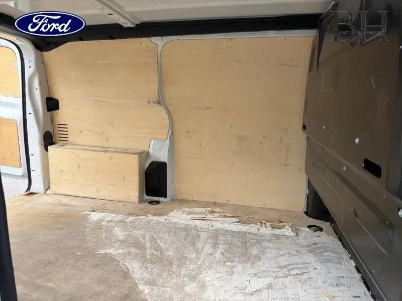 Vue intérieure arrière du fourgon Peugeot Expert blanc Banquise, montrant le plancher et les parois en bois clair.