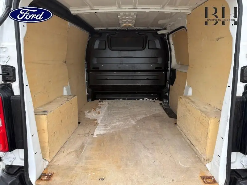 Vue intérieure arrière du fourgon blanc banquise PEUGEOT Expert avec plancher et protections latérales en bois.