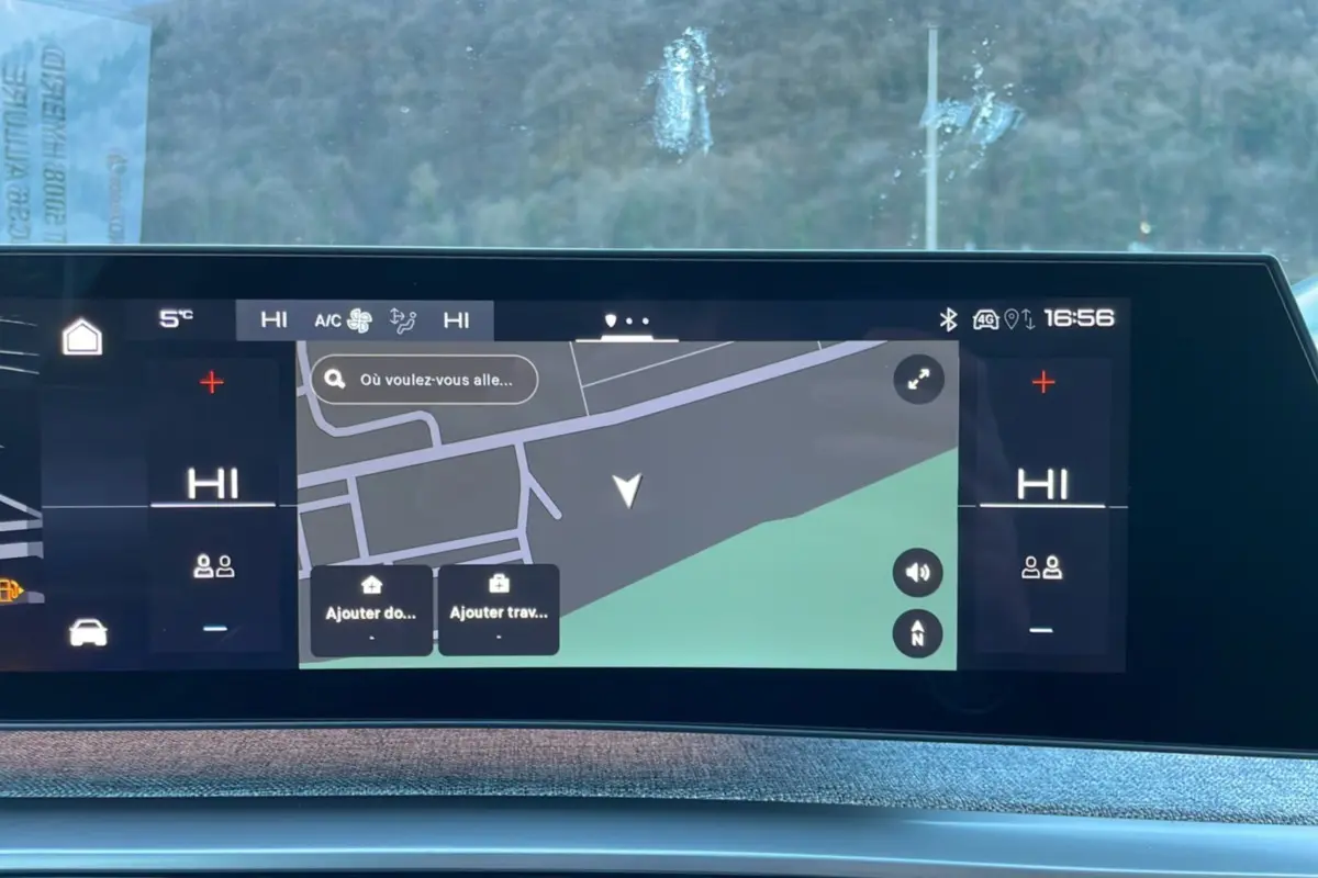 Écran tactile incurvé du tableau de bord du Peugeot 5008 gris titane, affichant la navigation GPS et la climatisation.