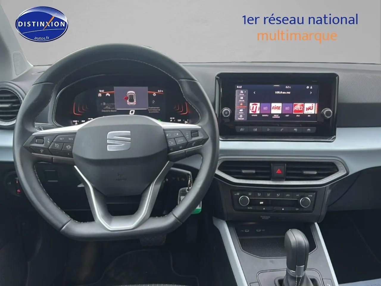 Vue intérieure centrée sur le volant méplat et le tableau de bord digital du SEAT Arona 2025 finition Copa, ambiance grise.