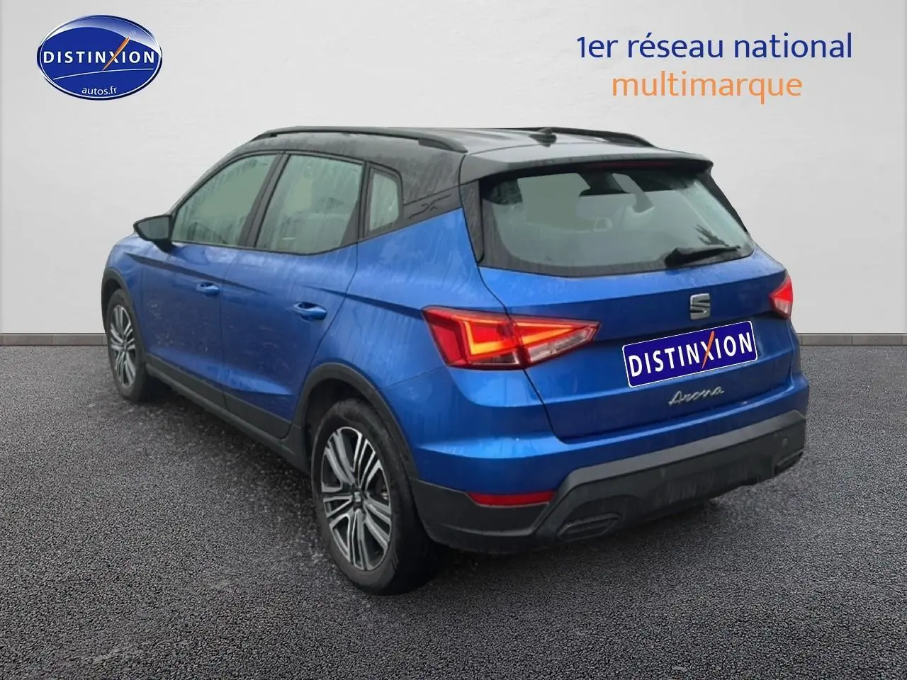 Vue 3/4 arrière droite d'un SEAT Arona bleu saphir avec toit noir et jantes 17 pouces urban design.