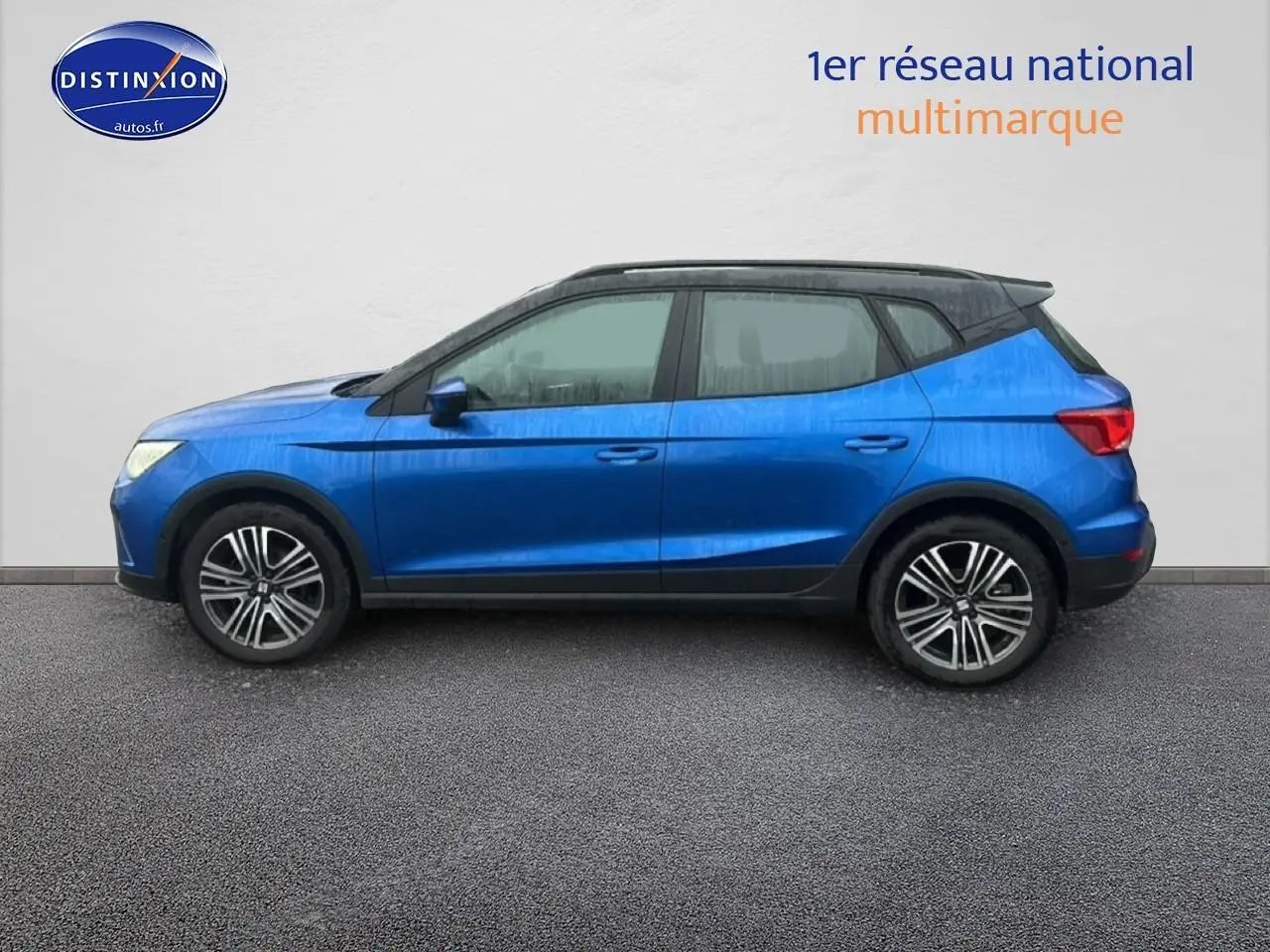 Vue de profil côté gauche d'un SEAT Arona 2025 bleu saphir avec toit noir et jantes 17 pouces urban design.