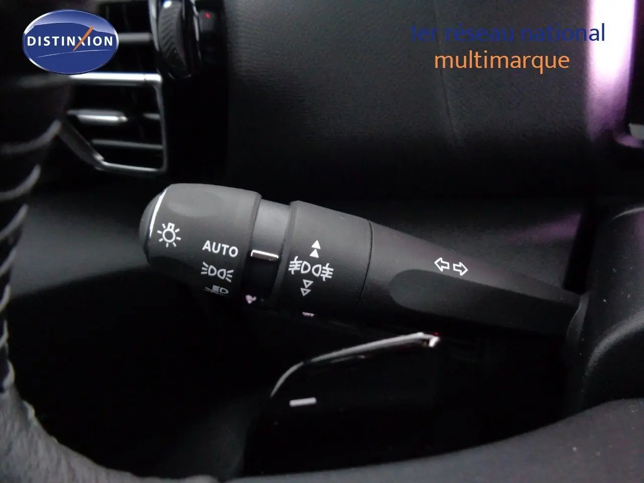 Gros plan sur la commande des feux et clignotants dans l’habitacle noir d’une Citroën C4 Gris Artense 2023.