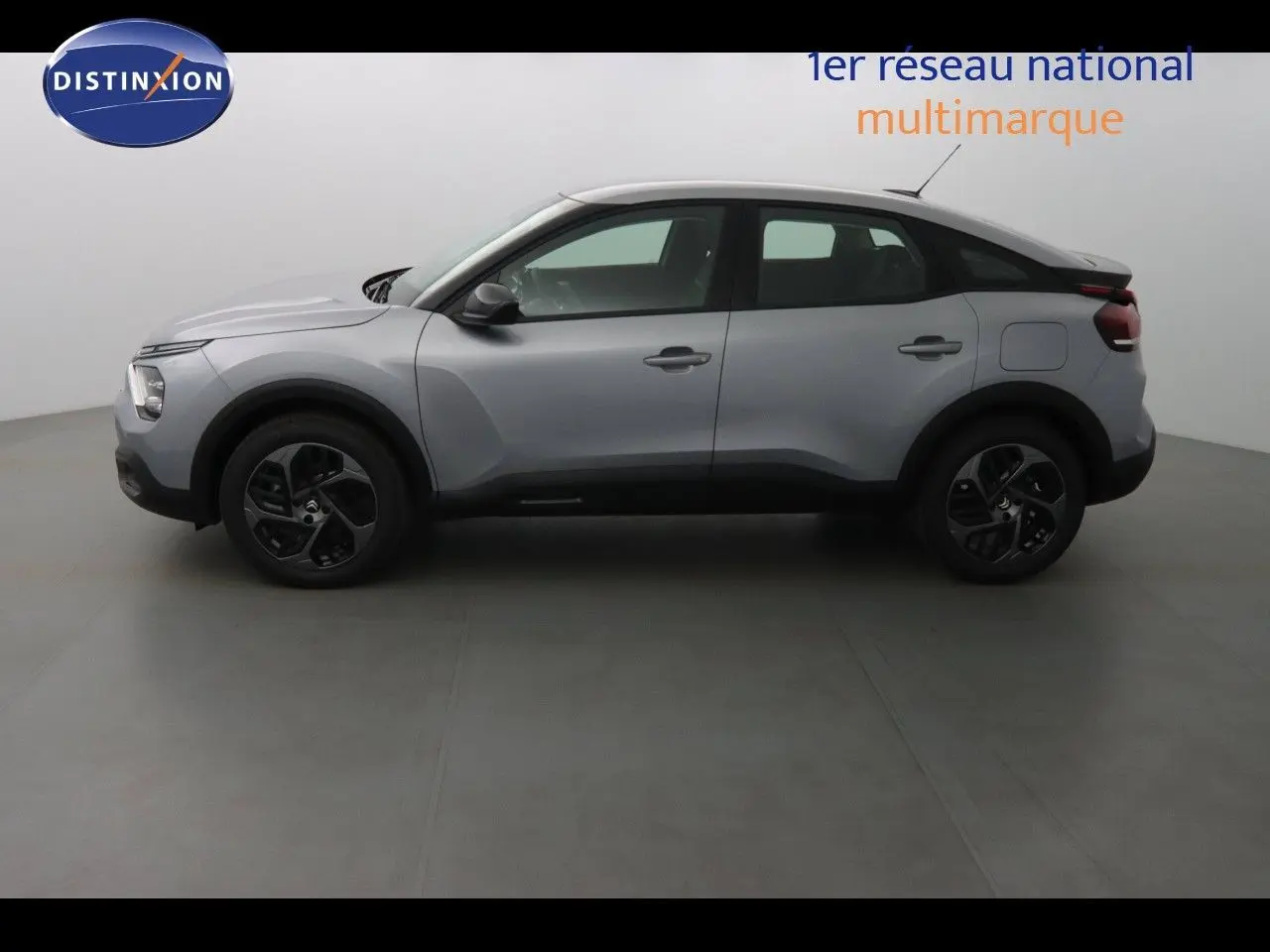Profil côté gauche d'une Citroën C4 2023 gris Artense métal avec jantes noires et lignes sculptées.