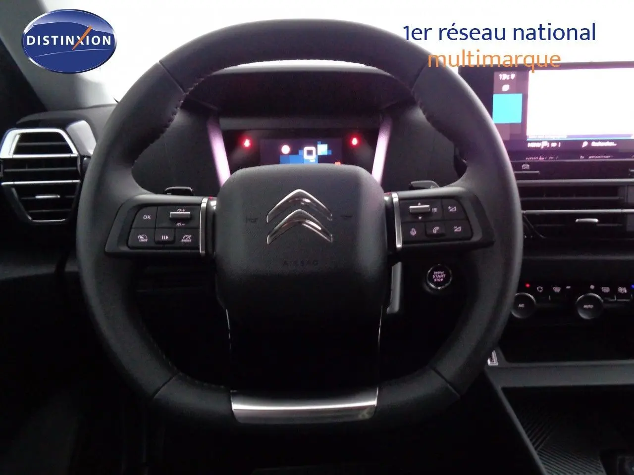 Vue intérieure centrée sur le volant noir de la Citroën C4 2023 avec tableau de bord digital et commandes intégrées.