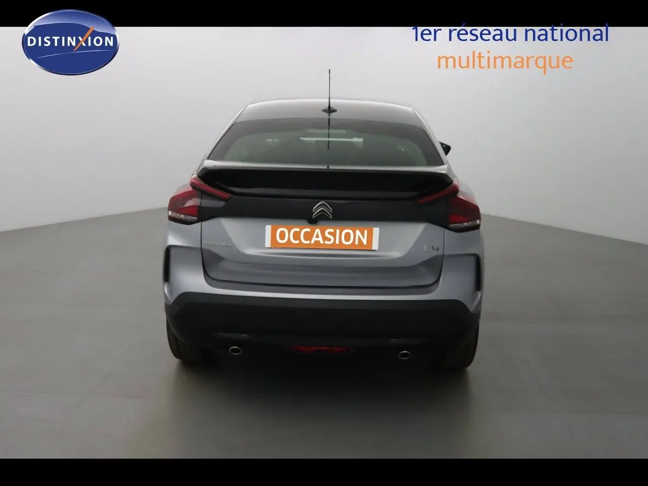 Vue arrière d'une Citroën C4 gris Artense métal 2023 avec feux arrière distinctifs et double sortie d'échappement.