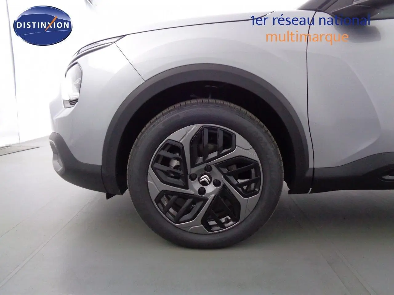 Gros plan sur la roue avant gauche d'une Citroën C4 gris Artense métal, avec jante alliage au design moderne.