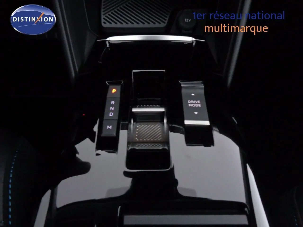 Gros plan sur la console centrale noire brillante de la Citroën C4 2023, avec sélecteur de boîte auto et bouton Drive Mode.