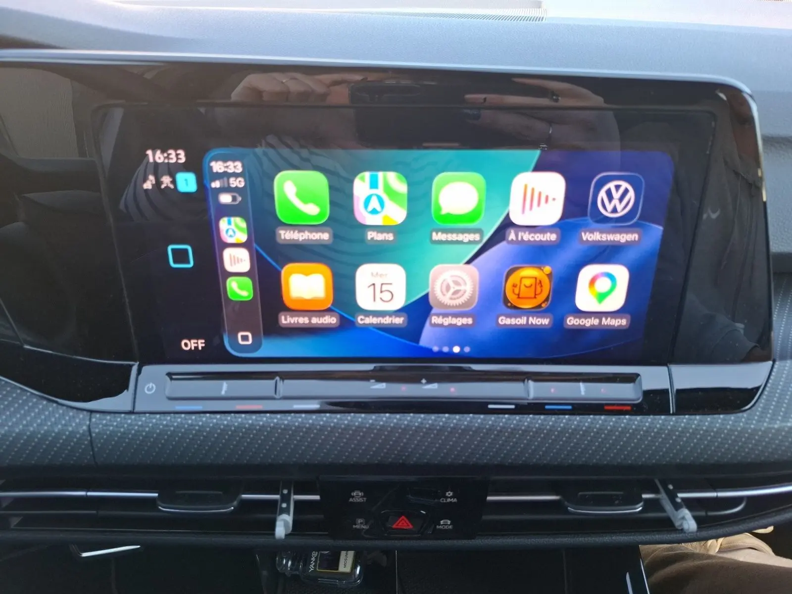 Écran tactile central affichant Apple CarPlay dans l’habitacle d’une Volkswagen Golf blanche, vue de face.