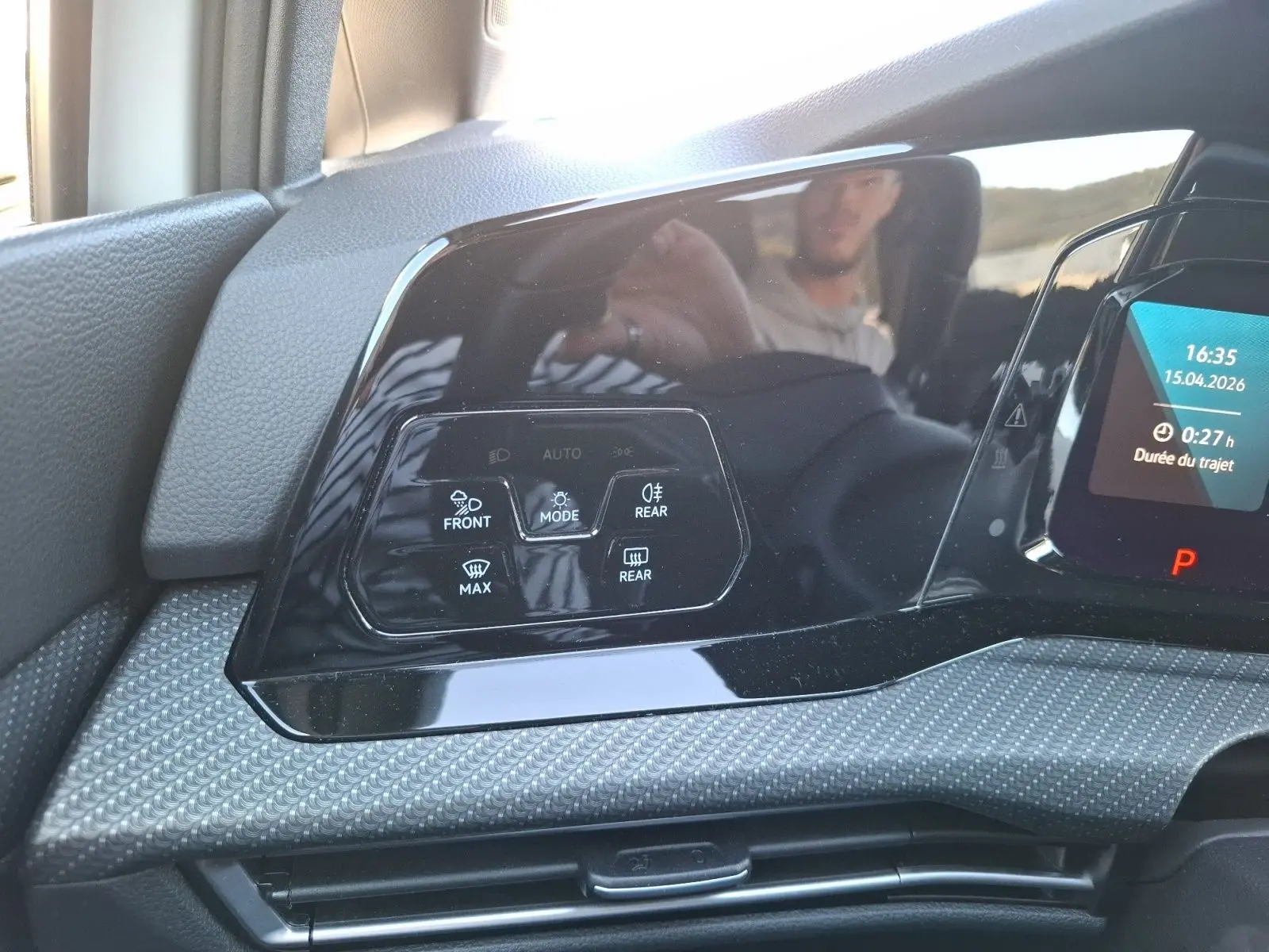 Gros plan sur les commandes de climatisation automatique noire dans l'habitacle d'une Volkswagen Golf blanche 2023.