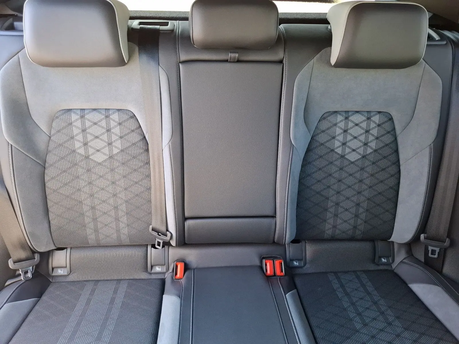 Vue rapprochée des sièges arrière noirs et gris de la Volkswagen Golf 1.5 E-TSI R-Line 2023 avec ceintures visibles.
