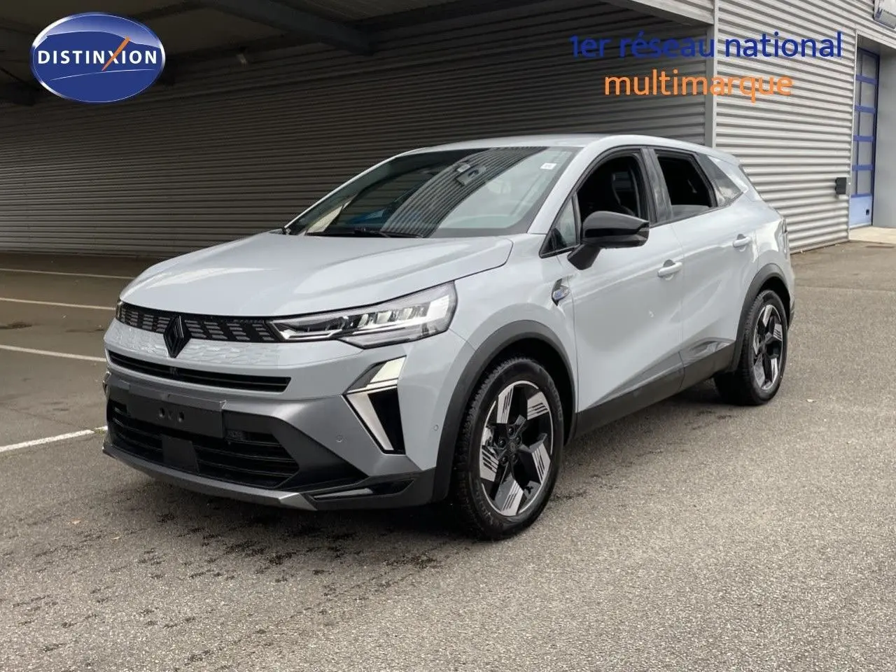 Renault Symbioz gris Rafale métal en 3/4 avant droit, SUV hybride avec calandre noire et jantes bicolores modernes.