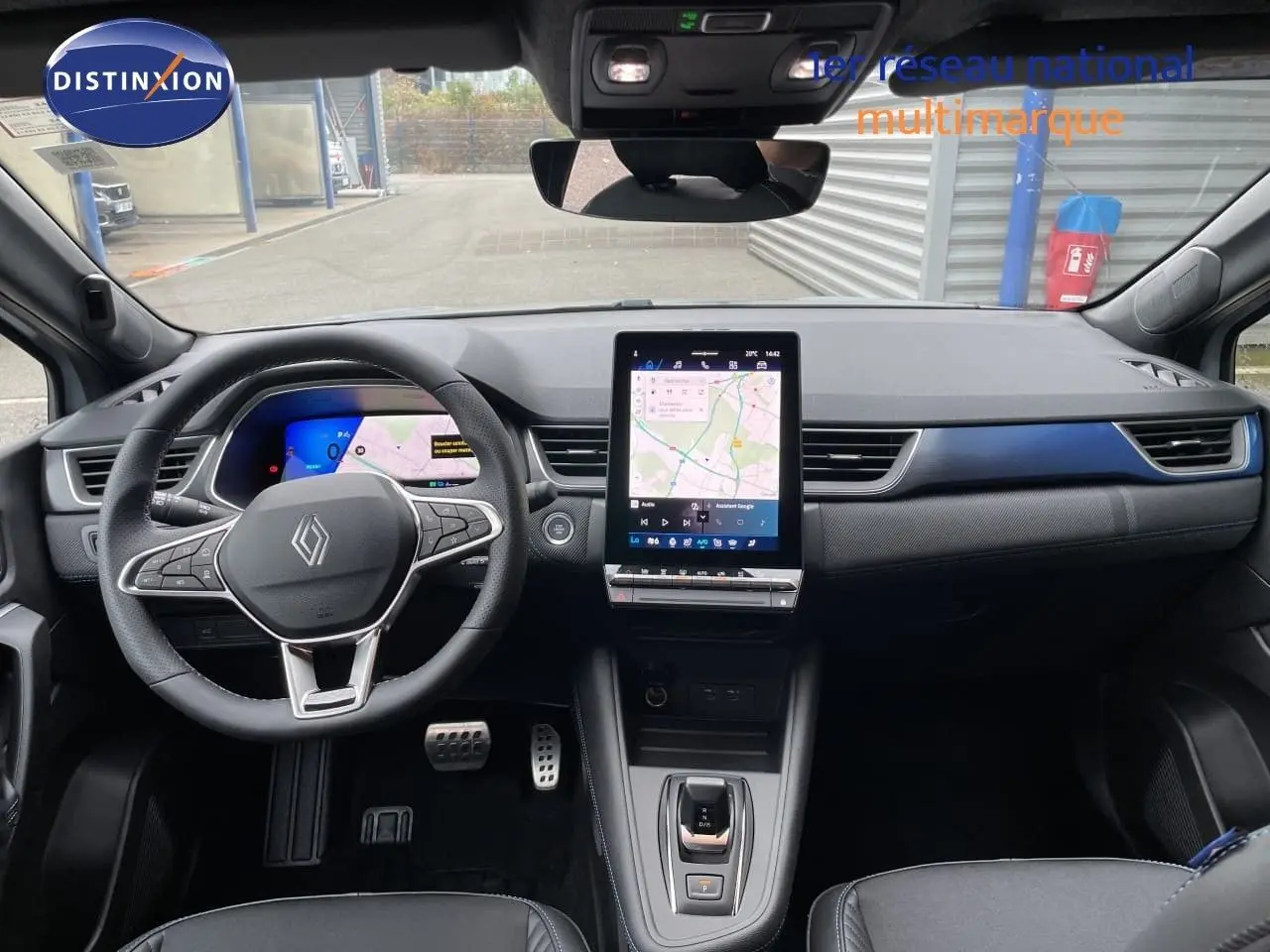 Vue intérieure avant du tableau de bord du Renault Symbioz gris Rafale métal avec écran tactile vertical et volant multifonction.