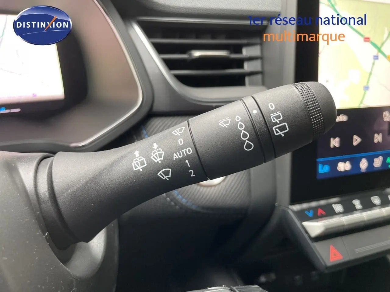 Gros plan sur la commande des essuie-glaces dans l’habitacle du Renault Symbioz gris Rafale Métal, avec écran tactile en arrière-plan.