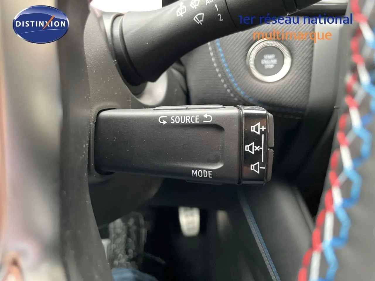 Gros plan sur la commande au volant gauche du Renault Symbioz gris Rafale Métal, avec bouton source et mode visible.