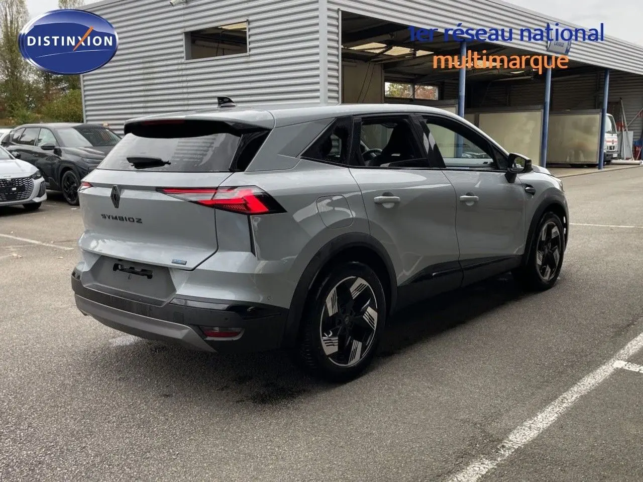 Renault Symbioz gris Rafale métal vu 3/4 arrière droit, avec feux arrière LED et jantes noires bicolores.