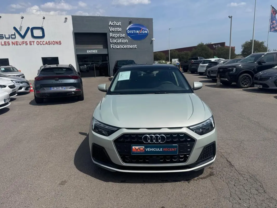 Vue avant d'une Audi A1 Sportback gris clair 2025 avec calandre noire et logo Audi visible en concession.