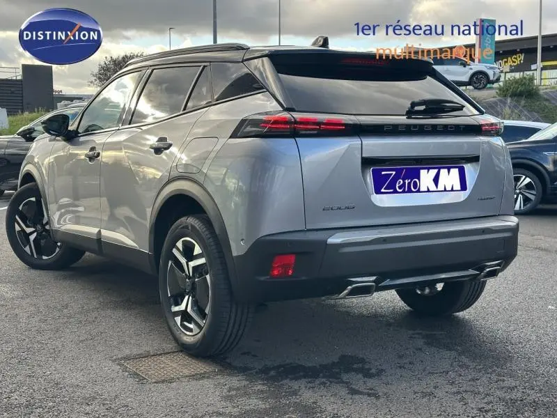 Vue 3/4 arrière droite d'un Peugeot 2008 hybride bleu avec feux arrière LED et jantes alliage noires.